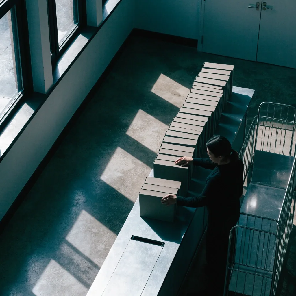 Documentation room seen from above at first light, desks and shelved policy volumes